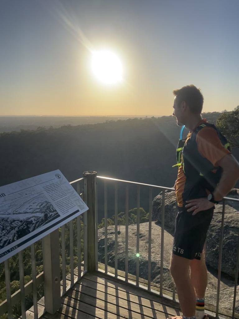 Jason Wheeler at a Blue Mountains lookout in running kit — First Choice Spinal & Sports Physiotherapy